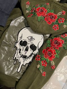 a pair of green shoes with red roses on them and a skull in the middle