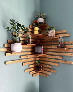 a wooden shelf with potted plants and other items on it in the corner of a room