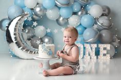 a baby is sitting in front of a cake