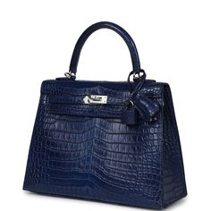 This rare Hermes Kelly, in the Sellier style, is in Bleu Indigo Aizome Matte Porosus Crocodile leather with palladium hardware and has tonal stitching, front flap, two straps with center toggle closure, clochette with lock and two keys, single rolled handle and a removable strap.The interior is lined with Bleu Indigo chevre and has a zip pocket with an Hermes engraved zipper pull and one open pocket on the opposite side.Payment for this item is by Bank Wire only unless other arrangements have be Crocodile Kelly Bag, Hermes Kelly Sellier, Blue Kelly Bag, Hermes Mini Kelly Crocodile, Hermes Kelly 25 Retourne, Hermes Bags Blue, Hermes Kelly 25, Hermes Bag, Crocodile Leather