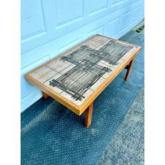 a coffee table sitting in front of a garage door on the side of a building