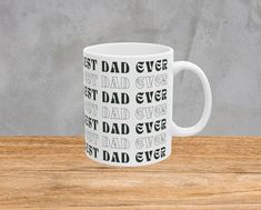 a white coffee mug with the words best dad ever printed on it sitting on a wooden table