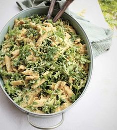 a bowl filled with broccoli and chicken on top of a white table cloth