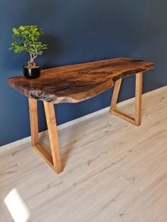 a wooden table with a potted plant sitting on it's top and legs