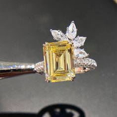 a yellow diamond ring sitting on top of a table