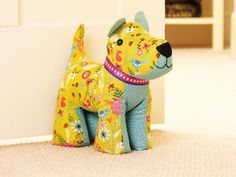 a yellow dog sitting on the floor next to a white wall and bookshelf