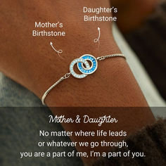 a woman wearing a bracelet with the words mother and daughter written in blue on it