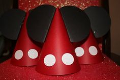 red party hat with white polka dots and mickey mouse ears on the top, sitting on a table