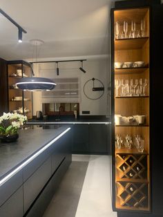 a kitchen filled with lots of counter top space and wine glasses on the shelves next to it