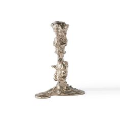 a tall silver vase sitting on top of a white floor