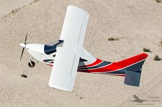 an aerial view of a small airplane on the ground with it's landing gear down