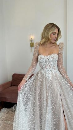 a woman in a white dress standing on a couch