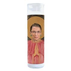 a candle with an image of a woman wearing glasses and a red dress on it