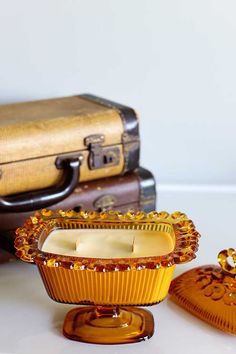 three pieces of luggage sitting next to each other on a white counter top with gold trimmings