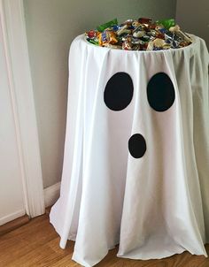 a white table with black polka dots on it and a ghost decoration in the corner