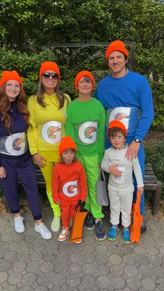 a group of people in costumes standing next to each other on a bench with trees behind them