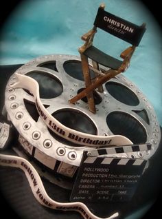 a chair sitting on top of a table next to a movie reel and clapper