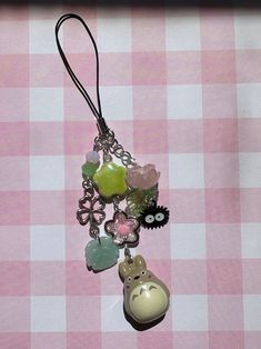 a close up of a necklace on a table with pink and white checkered cloth