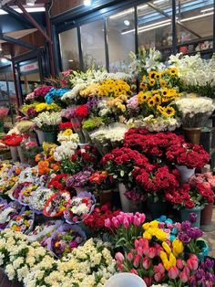 many different colored flowers are on display in the store