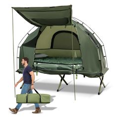 a man walking past a tent with a bed attached to it