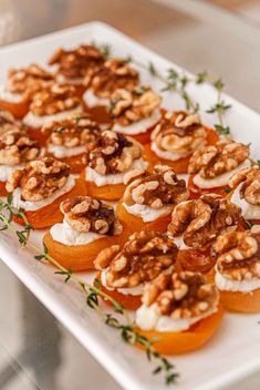 small appetizers are arranged on a white platter with garnishes