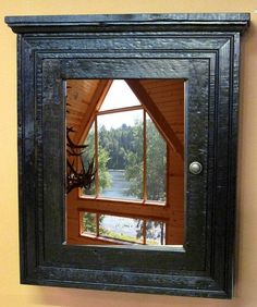 a deer head mounted to the side of a wooden framed mirror on a yellow wall