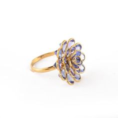 a gold ring with blue stones in the center and a flower design on it's side