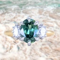 a close up of a ring with a green and white diamond