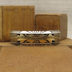 "Sterling silver and 1/20th 12KGF cuff bracelet. Stamped Sterling Mark Yazzie. 11/16\" wide. The inside measures 6 3/8\" including the 1 5/16\" opening. This is a small man's or large woman's bracelet. It can not be sized up or down because of the inset gold filled design. Good condition. Shipped by US mail. SBT-6" Gold Sterling Silver Cuff Bracelet, Classic Gold Sterling Silver Cuff Bracelet, Gold Sterling Silver Cuff Bracelet With Polished Finish, Unique Gold Sterling Silver Cuff Bracelet, Gold Sterling Silver Cuff Jewelry, Unique Gold Etched Cuff Bracelet, Unique Engraved Gold Cuff Bracelet, Unique Gold Engraved Cuff Bracelet, Black Onyx Ring