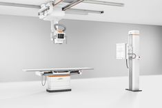 an empty hospital room with medical equipment on the floor and in the background is a white table