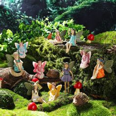 several fairy figurines sitting on top of moss