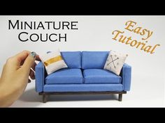 a miniature couch with pillows on it and the words miniature couch in front of it