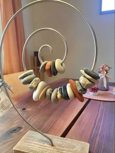 a wooden table topped with lots of different types of beads on top of a metal stand