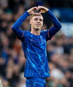 a soccer player is making a heart shape with his hands