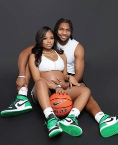 a man and woman sitting next to each other holding basketballs