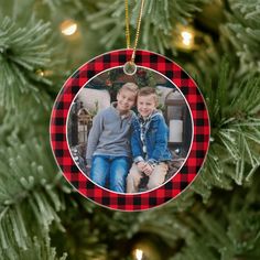 a christmas ornament with a photo of two children hanging from the top of a tree