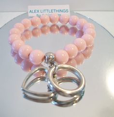 Pale pink stretch bracelet. Made with round pink acrylic beads, a heart charm and circle charm. Silver tone. Perfect to wear or give on Valentine's Day. All sales are final and as is. Thank you for looking. You may also love this: https://www.etsy.com/listing/469284246/pink-bead-necklace-square-round-beaded?ga_search_query=pink%2Bjewelry&ref=shop_items_search_41 Trendy Pink Stretch Bracelet For Valentine's Day, Pink Charm Bracelet With Round Beads For Gift, Pink Stretch Bracelet With Heart Charm For Gift, Pink Heart Bracelet For Valentine's Day, Handmade Pink Heart Stretch Bracelet, Pink Handmade Heart Stretch Bracelet, Valentine's Day Pink Stretch Bracelet With Heart Beads, Pink Heart Bracelet With Round Beads And Heart Charm, Pink Charm Bracelet With Round Beads For Valentine's Day