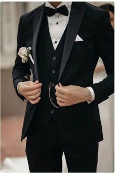 a man in a tuxedo is wearing a white boutonniere