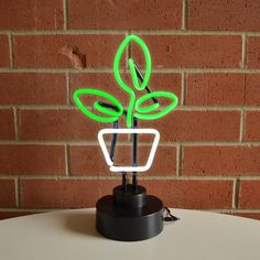 a neon green plant sitting on top of a white table next to a brick wall