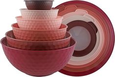 a stack of pink and red bowls sitting next to each other on top of plates