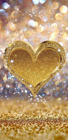 a golden heart with sparkles in the background on a glittery gold and silver surface