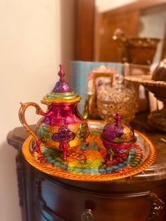 a colorful tea set sitting on top of a wooden table