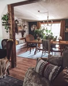 a living room filled with furniture and a wooden table next to a doorway that leads into a dining room