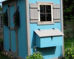 a small blue shed with a window on the side