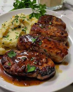 some meat and potatoes on a white plate