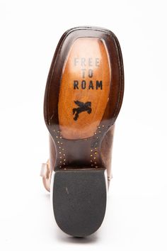 a pair of brown shoes with the word free to roam on it's heel