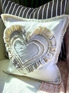 a heart shaped pillow sitting on top of a couch