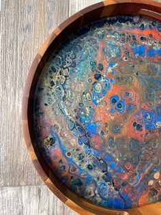 a wooden bowl filled with liquid on top of a table