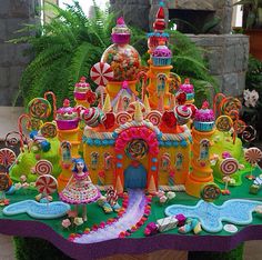 an elaborately decorated cake with candy and candies on it's display table