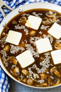 a pan filled with some kind of stew and tofu cubes on top of it